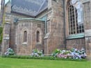 Lokal förankring i Falkenberg Den lokala kyrkan i Falkenberg med stenfasad och grönområde